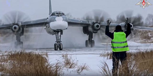 In this handout photo taken from video released by the Russian Defense Ministry Press Service on Nov. 30, 2022, a view of a Tu-95 strategic bomber of the Russian air force taxiing before takeoff for a joint air patrol with Chinese bombers at an airbase in an unspecified location in Russia.