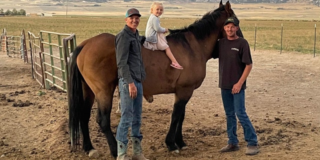 Shane Adams, right, smiles as he stands with Mongo, along with his brother, Dakota Adams, and his niece, Roslyn Adams.