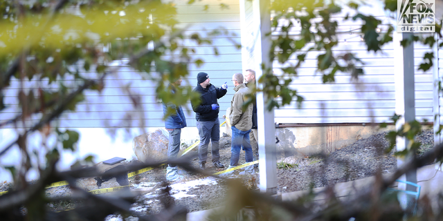 Law enforcement discuss outside the home where four University of Idaho student's were found dead.