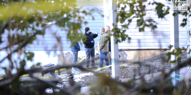 Law enforcement discuss outside the home where four University of Idaho student's were found dead.
