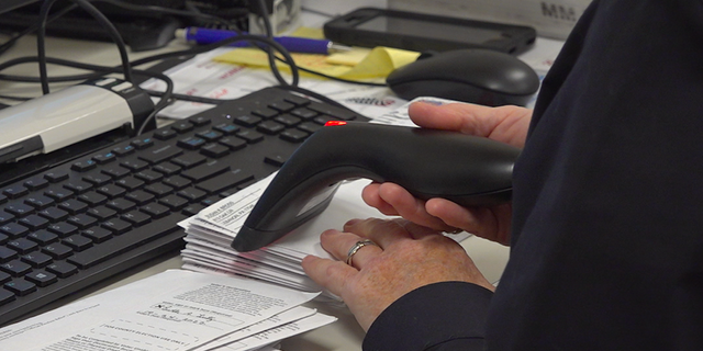 An elections office employee scans mail-in ballots in Lebanon, PA. 