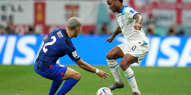 Sergino Dest of the United States and Raheem Sterling of England battle for possession during their match in Al Khor, Qatar, Friday, November 25, 2022.