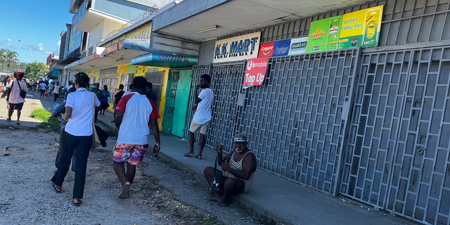 People gather outside closed shops in Honiara, Solomon Islands following an earthquake on Tuesday Nov 22, 2022.