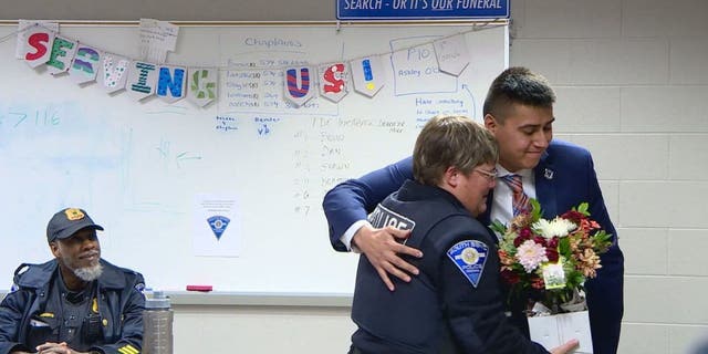 Roberto Theiss hugs South Bend Officer Anne Hayes 24 years after she saved his life as a toddler.
