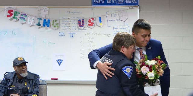 Roberto Theiss hugs South Bend Officer Anne Hayes 24 years after she saved his life as a toddler.