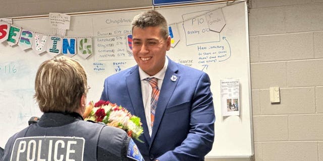 Roberto Theiss hands flowers to South Bend police officer Anne Hayes 24 years after she saved his life.