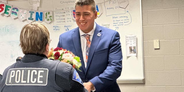 Roberto Theiss hands flowers to South Bend police officer Anne Hayes 24 years after she saved his life.