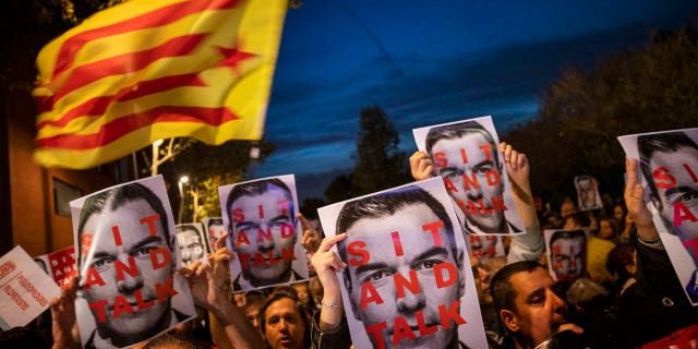 Catalonia pro-Independence demonstrators hold photos of Prime Minister and Socialist leader Pedro Sánchez, as they wait for his arrival outside a campaigning meeting in Viladecans, near Barcelona, Spain, on Oct. 30, 2019.
