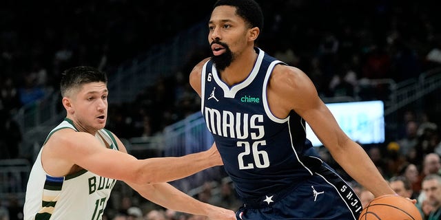 Dallas Mavericks' Spencer Dinwiddie, right, drives past Milwaukee Bucks' Grayson Allen during the first half of an NBA basketball game Sunday, Nov. 27, 2022, in Milwaukee. 