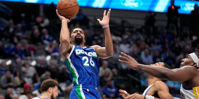 Dallas Mavericks guard Spencer Dinwiddie, #26, takes a shot as the Golden State Warriors' Jordan Poole, second from right, and Kevon Looney, right, defend in the first half of an NBA basketball game on Tuesday, Nov. 29, 2022, in Dallas We do.  , 