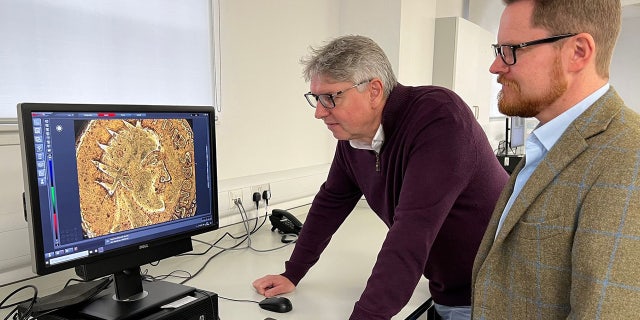 Profesorii Paul N. Pearson și Jesper Ericsson, The Hunterian, Universitatea din Glasgow, se uită la piesa Sponsian la microscop.