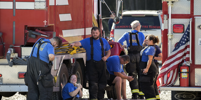 Members with the Waynesville Fire and Rescue Department take a break from battling the Symrise chemical plant fire on Nov. 7, in Brunswick, Georgia.