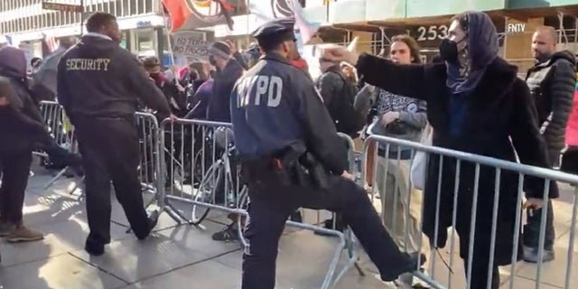 A demonstrator rings a bell near the ear of an NYPD officer during a Monday protest near City Hall.