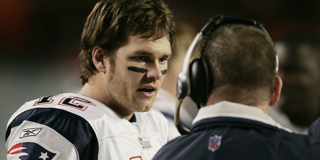 Tom Brady, #12, talks to offensive coordinator Charlie Weis of the New England Patriots during the game against the Miami Dolphins at Pro Player Stadium on Dec. 20, 2004 in Miami.