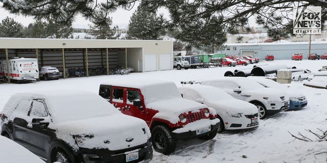 Several cars sit in a maintenance shop's parking lot after being towed away from a home where four University of Idaho students were murdered. 