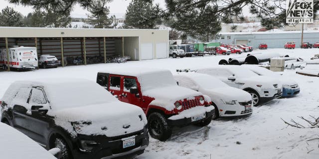 Several cars sit in a maintenance shop's parking lot after being towed away from a home where four University of Idaho students were murdered. 