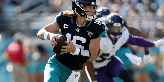 Trevor Lawrence of the Jacksonville Jaguars battles during the first half against the Baltimore Ravens at TIAA Bank Field on November 27, 2022 in Jacksonville, Florida.