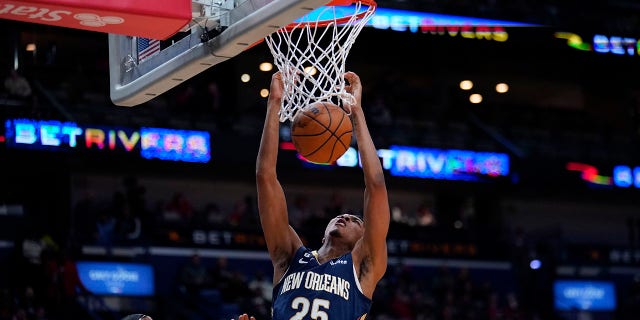New Orleans Pelicans guard Trey Murphy III, #25, slam dunks over Chicago Bulls center Andre Drummond in the second half of an NBA basketball game in New Orleans, Wednesday, Nov. 16, 2022.
