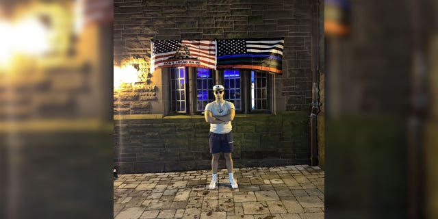 Lucas Turco, student at Trinity College, stands in front of his flags that were taken down by school officials.