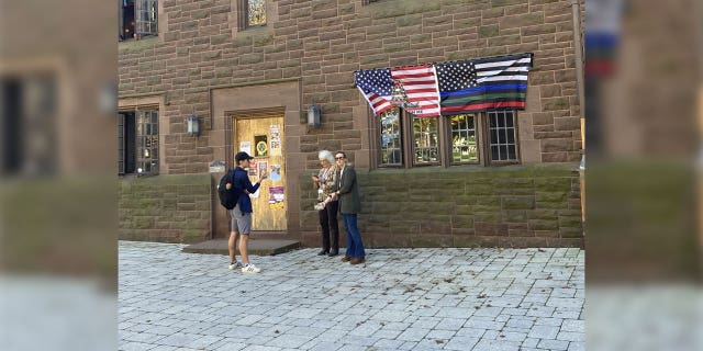 Flinn McCole, student at Trinity College, converses with the school officials who moments later took down his flags.