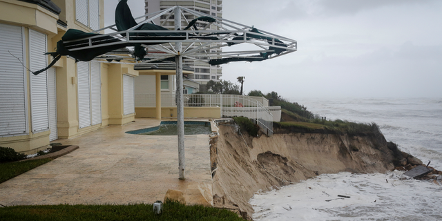 Waves crash into a beachfront house after Hurricane Nicole made landfall on Florida's east coast, in Daytona Beach Shores.