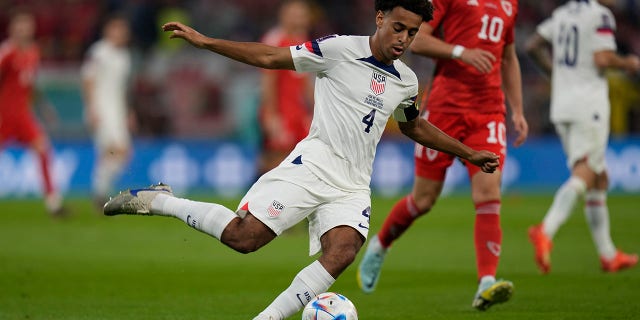 Tyler Adams of the United States kick the ball in front of Wales' Aaron Ramsey during the World Cup, group B soccer match between the United States and Wales, at the Ahmad Bin Ali Stadium in in Doha, Qatar, Monday, Nov. 21, 2022.