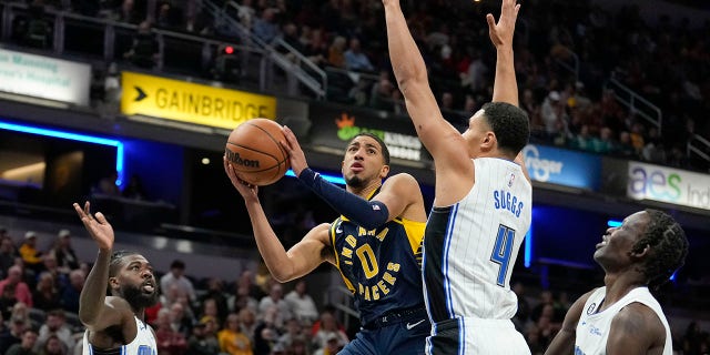 Indiana Pacers guard Tyrese Haliburton shoots around Orlando Magic guard Jalen Suggs in Indianapolis, Saturday, Nov. 19, 2022.