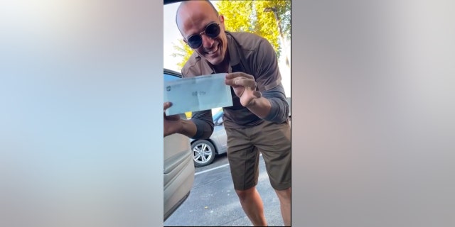 Yoel Diaz shows off his UPS paycheck — the first check he earned while working in America. Diaz moved to this country in 2021.