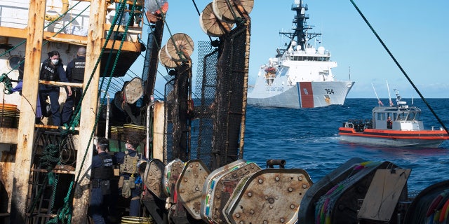 Guardsmen from the cutter James, in background right, conduct a boarding of a fishing vessel in the eastern Pacific Ocean, on Aug. 4, 2022. (Petty Officer 3rd Class Hunter Schnabel/U.S. Coast Guard via AP)