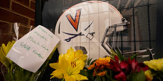 Flowers and commemorative notes line the walkway at Scott Stadium after three football players were killed in a shooting on the grounds of the University of Virginia on Tuesday, Nov. 15, 2022, in Charlottesville.  Virginia.