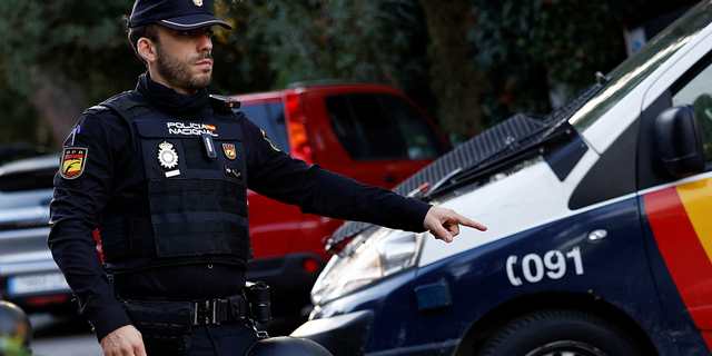 A Spanish police officer gestures outside the Ukrainian embassy in Madrid on Wednesday following an explosion.