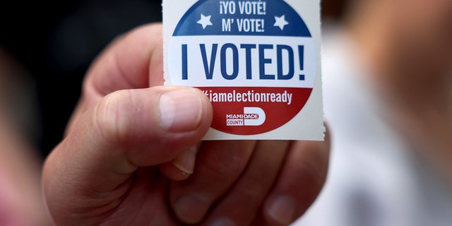 A voter shows off their, 'I Voted", sticker after casting their ballot at a polling station on November 08, 2022 in Miami, Florida.