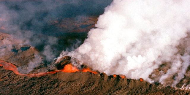 FILE - A gaseous cloud rises from the crater of Mauna Loa, center, on the big island of Hawaii, April 4, 1984. The ground is shaking and swelling at Mauna Loa, the largest active volcano in the world, indicating that it could erupt. Scientists say they don't expect that to happen right away but officials on the Big Island of Hawaii are telling residents to be prepared in case it does erupt soon.