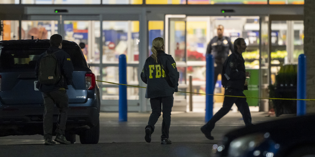 Law enforcement, including the FBI, work the scene of a mass shooting at a Walmart on Nov. 23, in Chesapeake, Virginia.