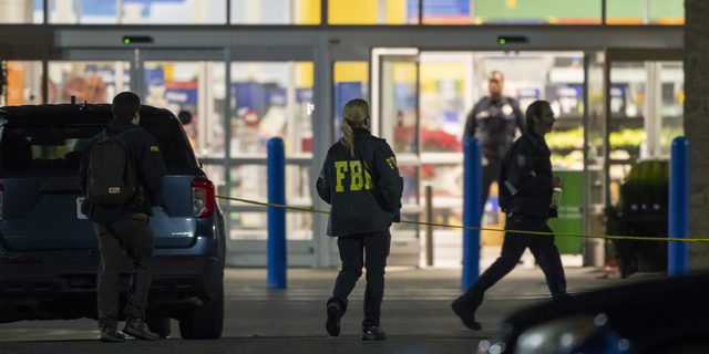 Law enforcement, including the FBI, work the scene of a mass shooting at a Walmart on Nov. 23, in Chesapeake, Virginia.