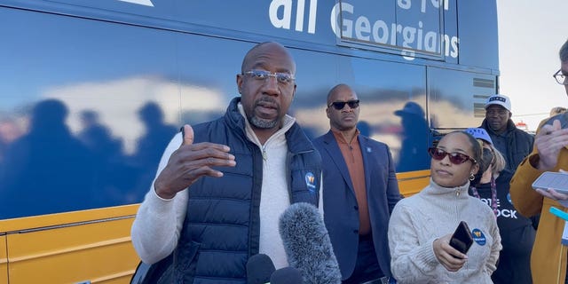 Georgia Democratic Sen. Raphael Warnock speaks to members of the media after a campaign rally in Conyers, Georgia on November 21, 2022.