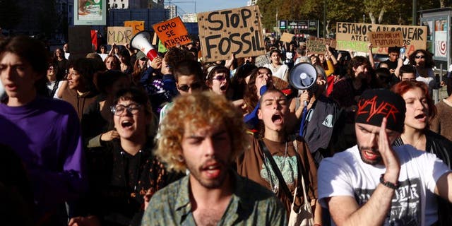 Protesters for climate change and against the use of fossil fuels shout slogans in Lisbon, Portugal, 12 November 2022.