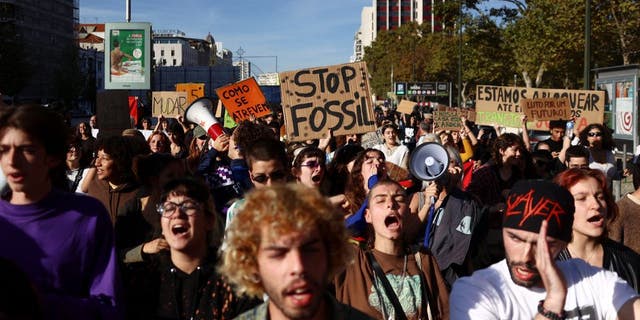 Protesters for climate change and against the use of fossil fuels shout slogans in Lisbon, Portugal, 12 November 2022.