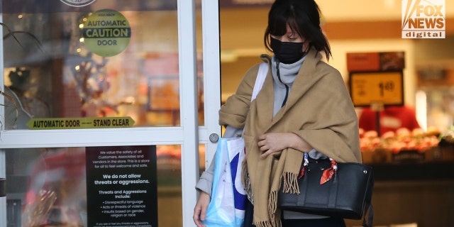 Young An saliendo de una tienda de comestibles con dulces de Halloween.