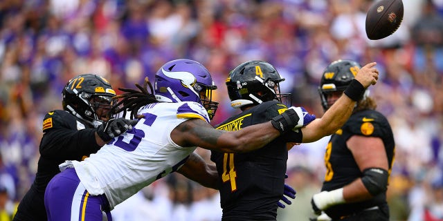 Washington Commanders quarterback Taylor Heinicke (4) gets hit from behind by Minnesota Vikings linebacker Za'Darius Smith (55) during the first half, Nov. 6, 2022, in Landover, Maryland.