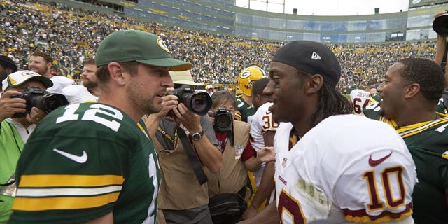 FILE - Green Bay's Aaron Rogers, left, shakes hands with Washington's Robert Griffin III after their game at Lambeau Field in Green Bay, Wisconsin.