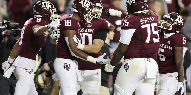 Donovan Green #18  celebrates his touchdown with Evan Stewart #1, Noah Thomas #9, and Kam Dewberry #75 of the Texas A&amp;M Aggies during the first half against the LSU Tigers at Kyle Field on November 26, 2022 in College Station, Texas. 