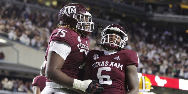 Devon Achane #6 of the Texas A&amp;M Aggies celebrates his rushing touchdown with Kam Dewberry #75 of the Texas A&amp;M Aggies against the LSU Tigers during the second half at Kyle Field on November 26, 2022 in College Station, Texas. 
