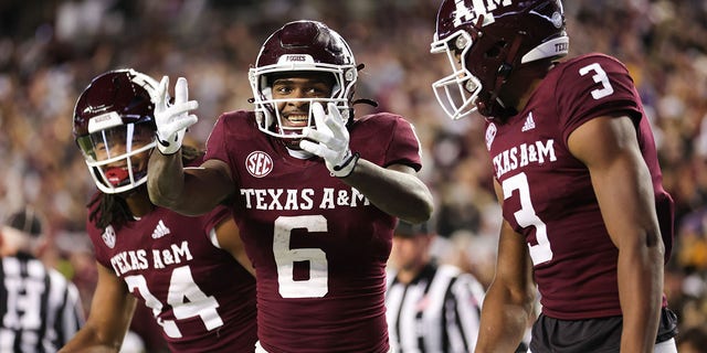 Devon Achane #6 celebrates his rushing touchdown with Devin Price #3, and Max Johnson #14 of the Texas A&amp;M Aggies against the LSU Tigers during the second half at Kyle Field on November 26, 2022 in College Station, Texas. 