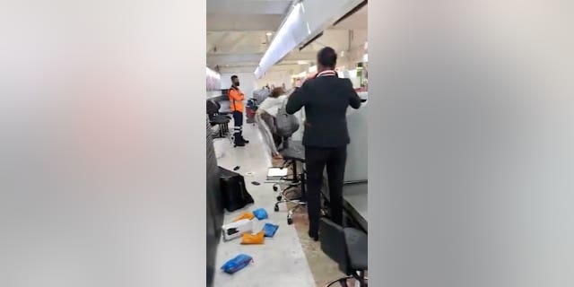 A passenger with an expired passport was refused entry when he tried to check in for his flight - and went on strike, then threw it at an Emirates employee and others.