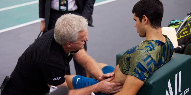 Carlos Alcaraz of Spain receives treatment after being injured in a match against Holger Vitus Nodskov Rune of Denmark in the quarterfinals during of the Rolex Paris Masters Nov. 4, 2022, in Paris.