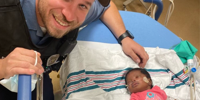 Kansas City Police officer Richard DuChaine in photo with baby he helped save. 