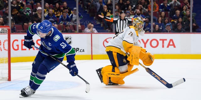 Juuse Saros of the Nashville Predators, right, celebrates after Bo Horvat of the Vancouver Canucks, left, missed a shot in the shootout at Rogers Arena on Nov. 5, 2022, in Vancouver, British Columbia, Canada.