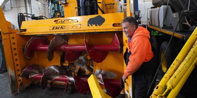 Heavy equipment operator Don Beitz prepares for a Friday snowstorm in upstate New York, where up to four feet of snow is expected to fall