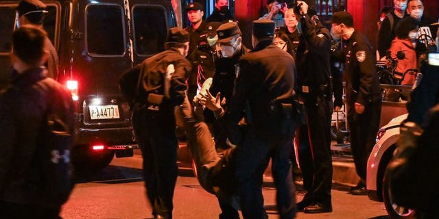 A man is arrested while people gathering on a street in Shanghai on November 27, 2022, where protests against China's zero-Covid policy took place the night before following a deadly fire in Urumqi, the capital of the Xinjiang region. (HECTOR RETAMAL/AFP via Getty Images)